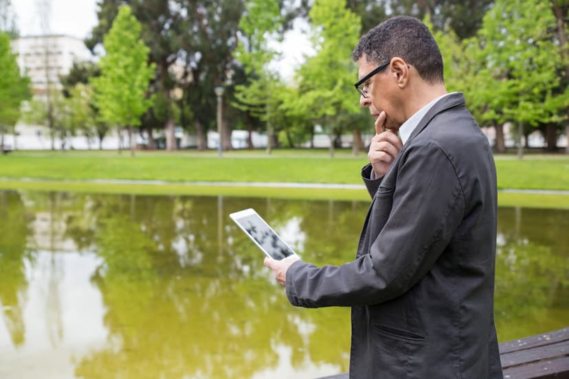Man using tablet in a park, representing technology and nature coexisting